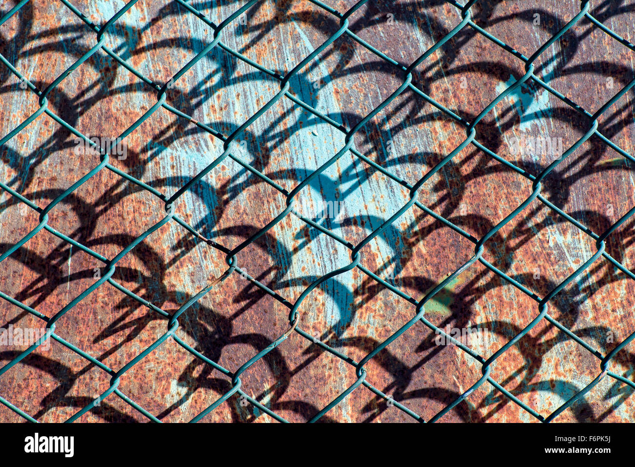 Graphic patterns created by wire mesh, hurricane, or cyclone steel fence Stock Photo