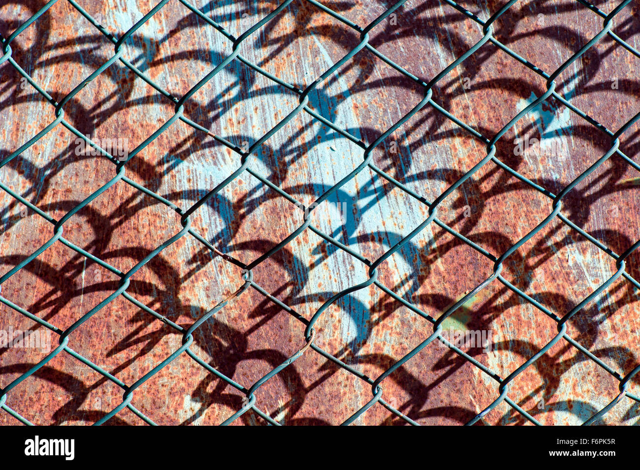 Graphic patterns created by wire mesh, hurricane, or cyclone steel fence Stock Photo