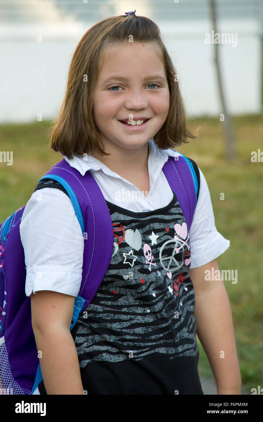 Young girl waiting for school bus on first day of school. Stock Photo