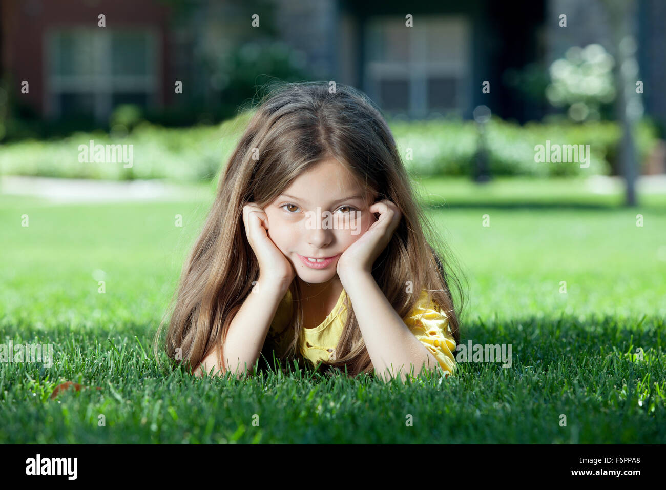 portrait of little girl laying on the grass in summer environment Stock ...