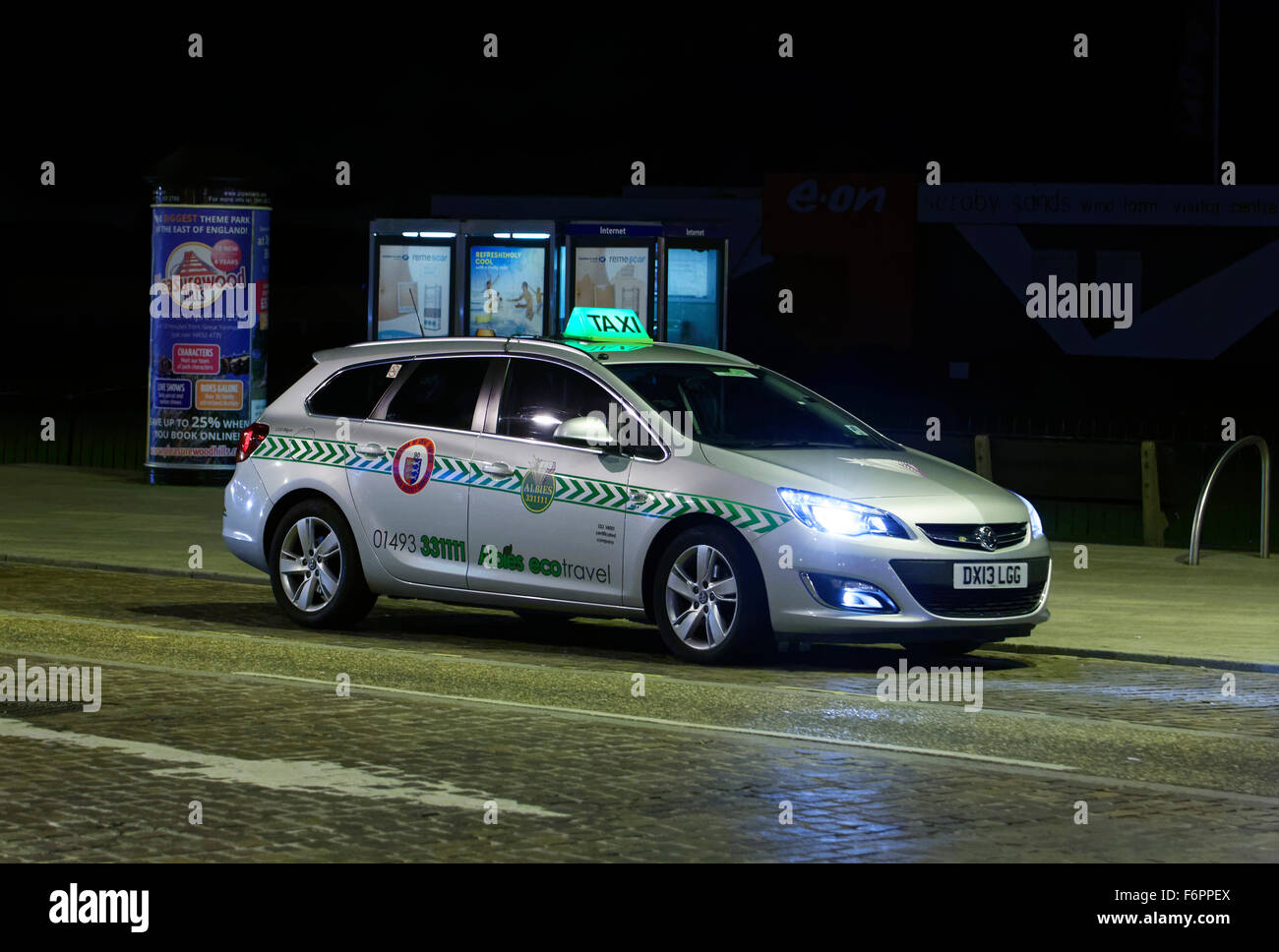 taxi cab at night in street in UK Stock Photo