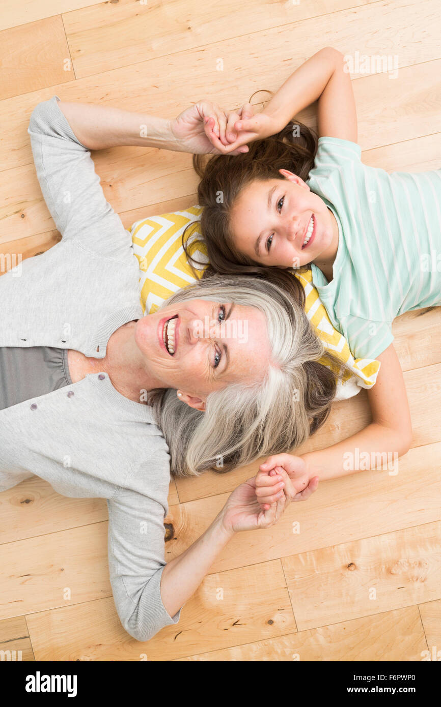 Caucasian grandmother and granddaughter laying on floor Stock Photo