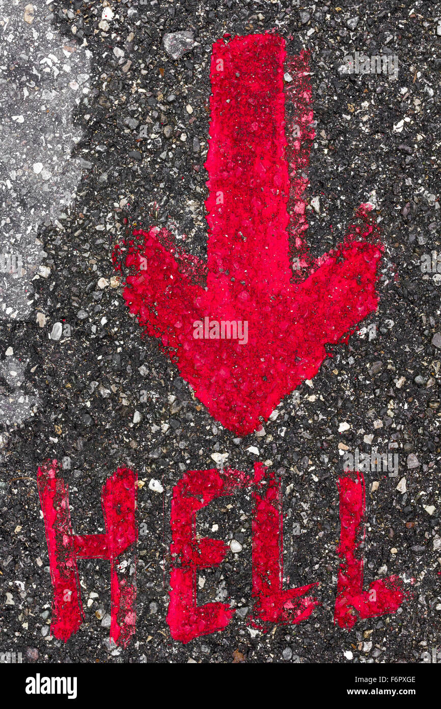 A red arrow painted on the asphalt showing the direction to hell. Stock Photo