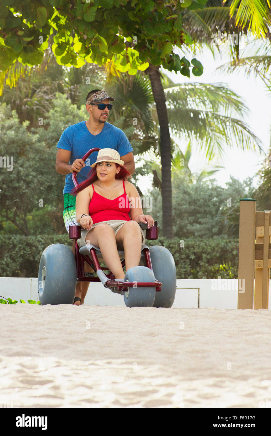 Man pushing paraplegic girlfriend in wheelchair Stock Photo
