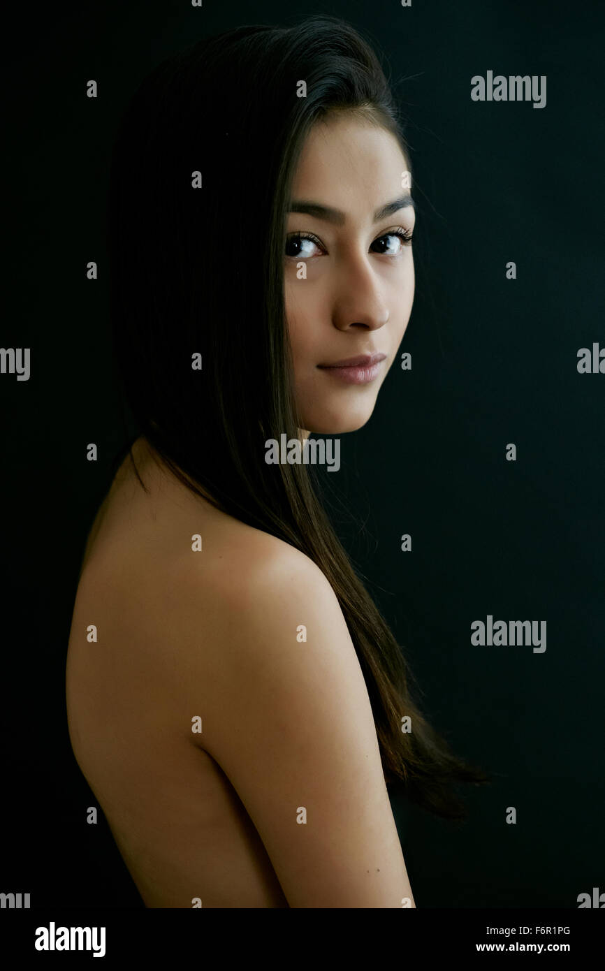 Nude Hispanic woman looking over shoulder Stock Photo - Alamy