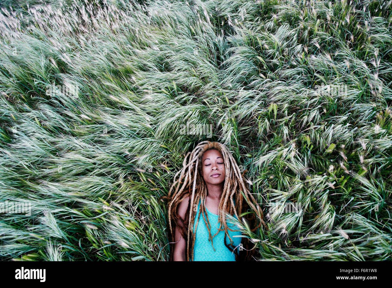 Black woman laying in grass Stock Photo
