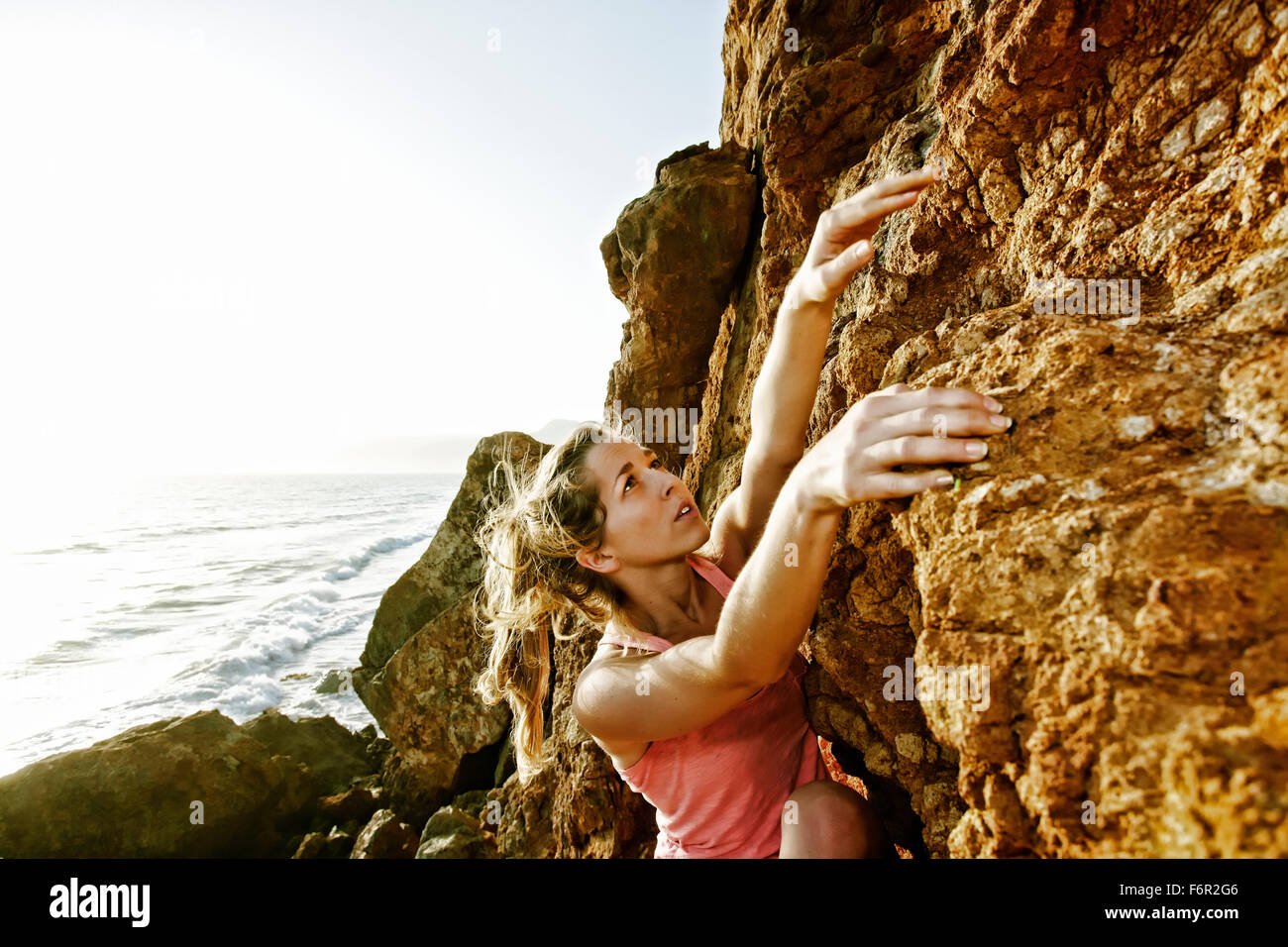 Woman climbing rock formation Stock Photo