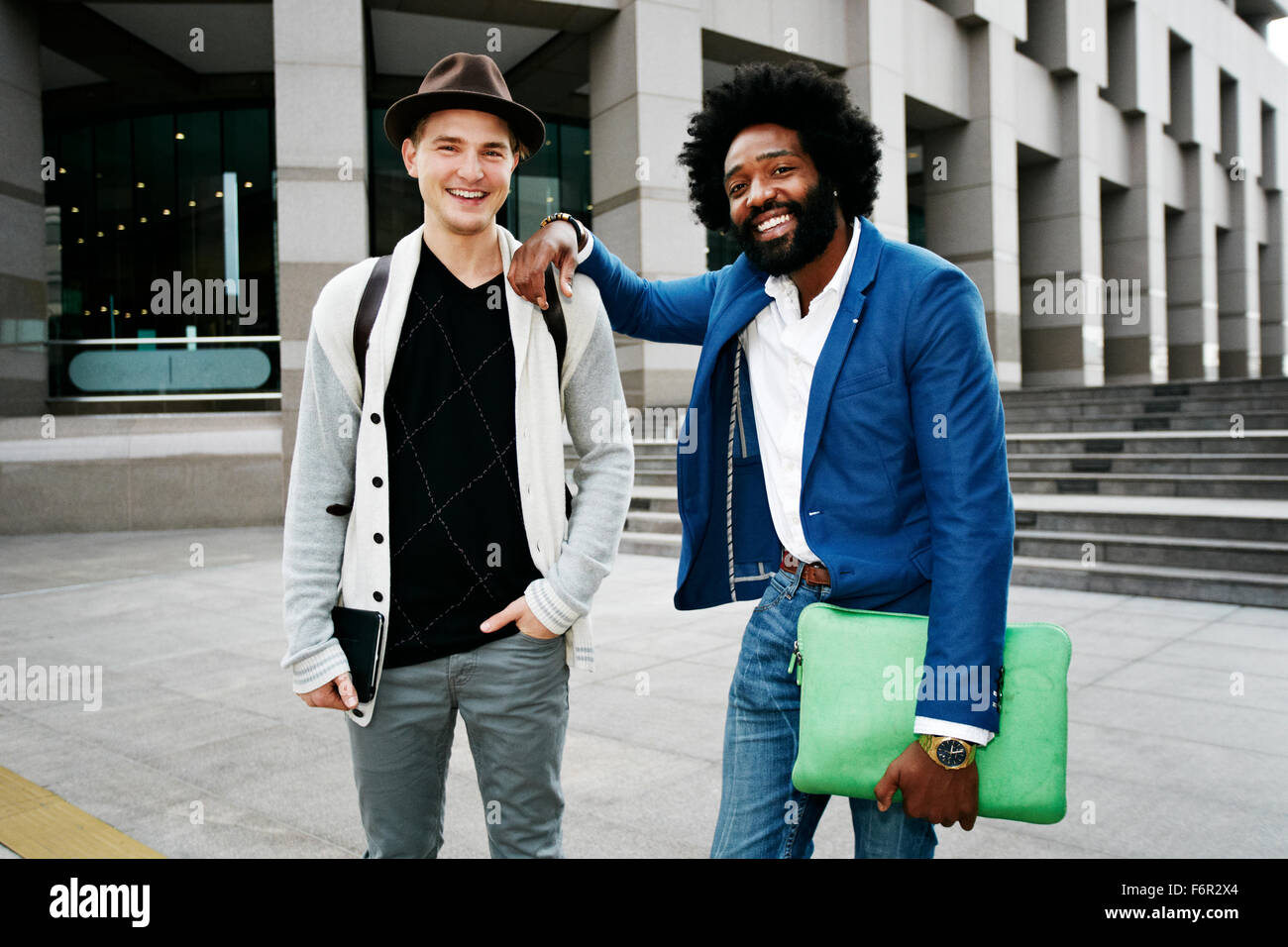 Two businessmen standing together and smiling Stock Photo - Alamy