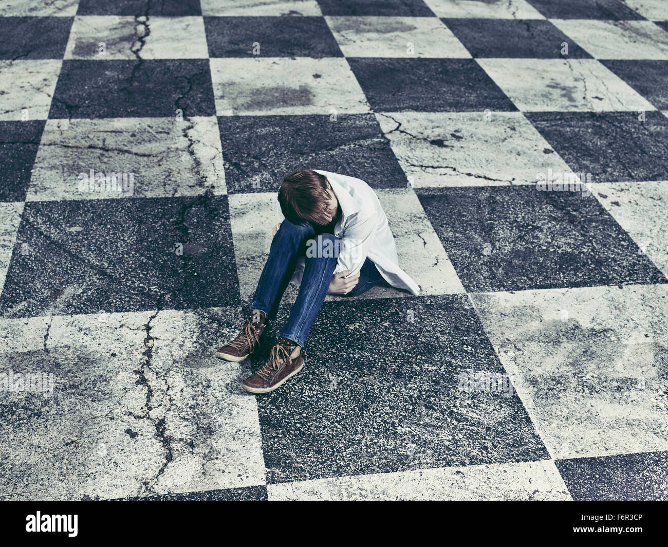 Conceptual, lonely man and checkered ground Stock Photo - Alamy