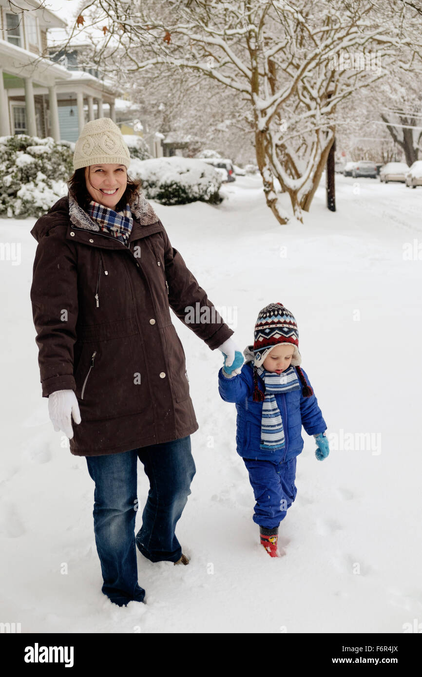 Caucasian mother and son walking in snow Stock Photo