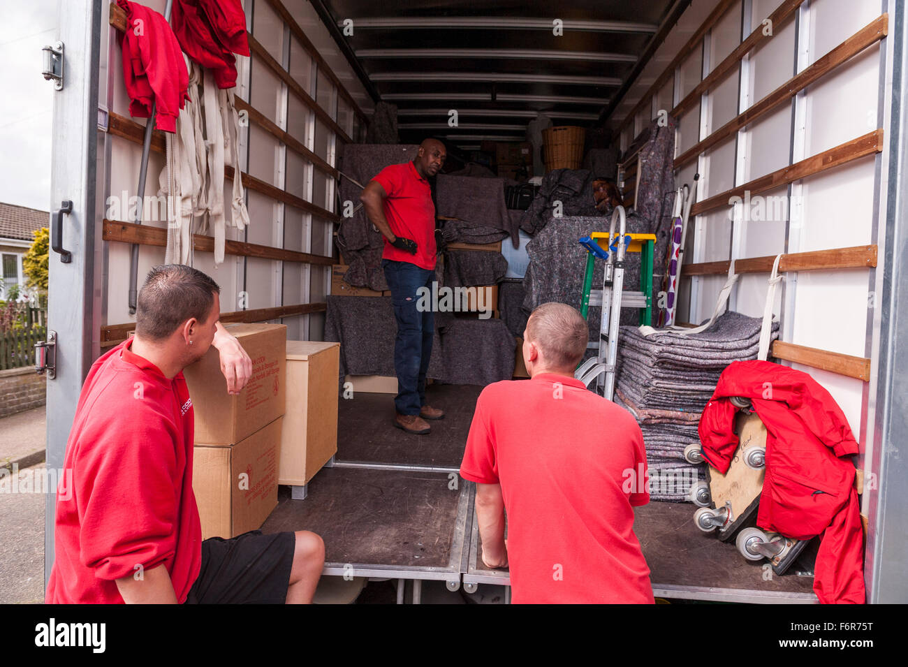 Removal men packing a removal van helping family move house in the Uk Stock Photo
