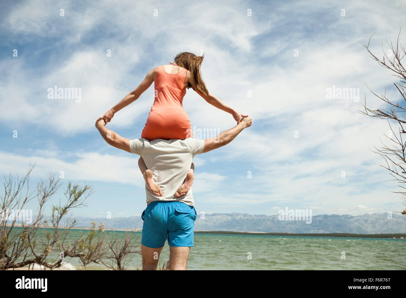 Young woman sitting on shoulder of her boyfriend Stock Photo Alamy