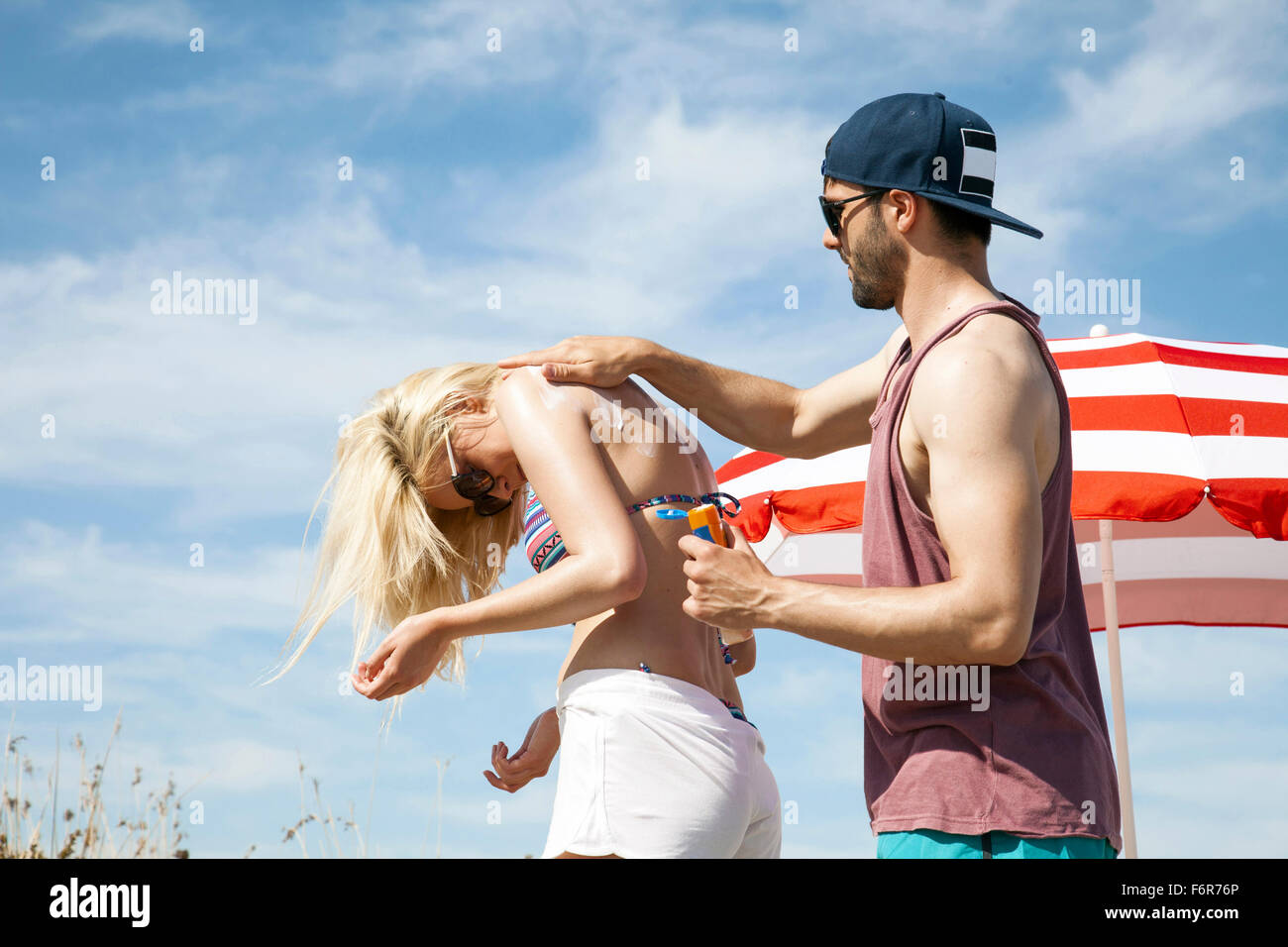 Man applying suntan lotion woman hires stock photography and images