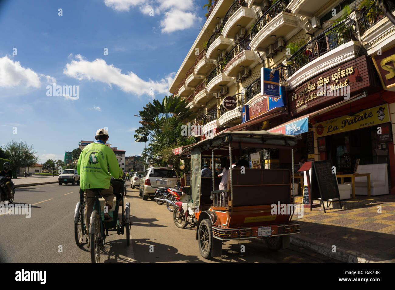 Phnom Penh, Cambodia: Sightseeing by tuk tuk and cyclo (rickshaw) on Sisowath Quay. Stock Photo