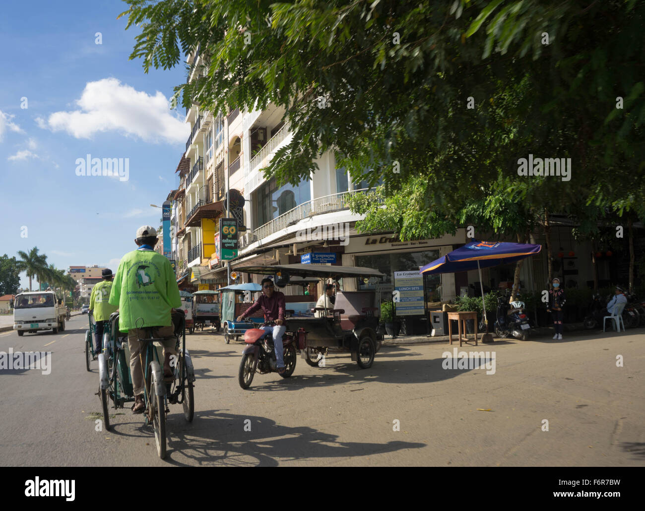 Phnom Penh, Cambodia: Sightseeing by tuk tuk and cyclo (rickshaw) on Sisowath Quay. Stock Photo