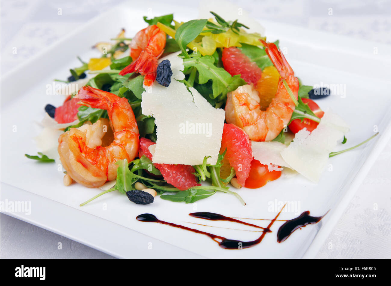 Big shrimp and green salad with cheese on plate Stock Photo