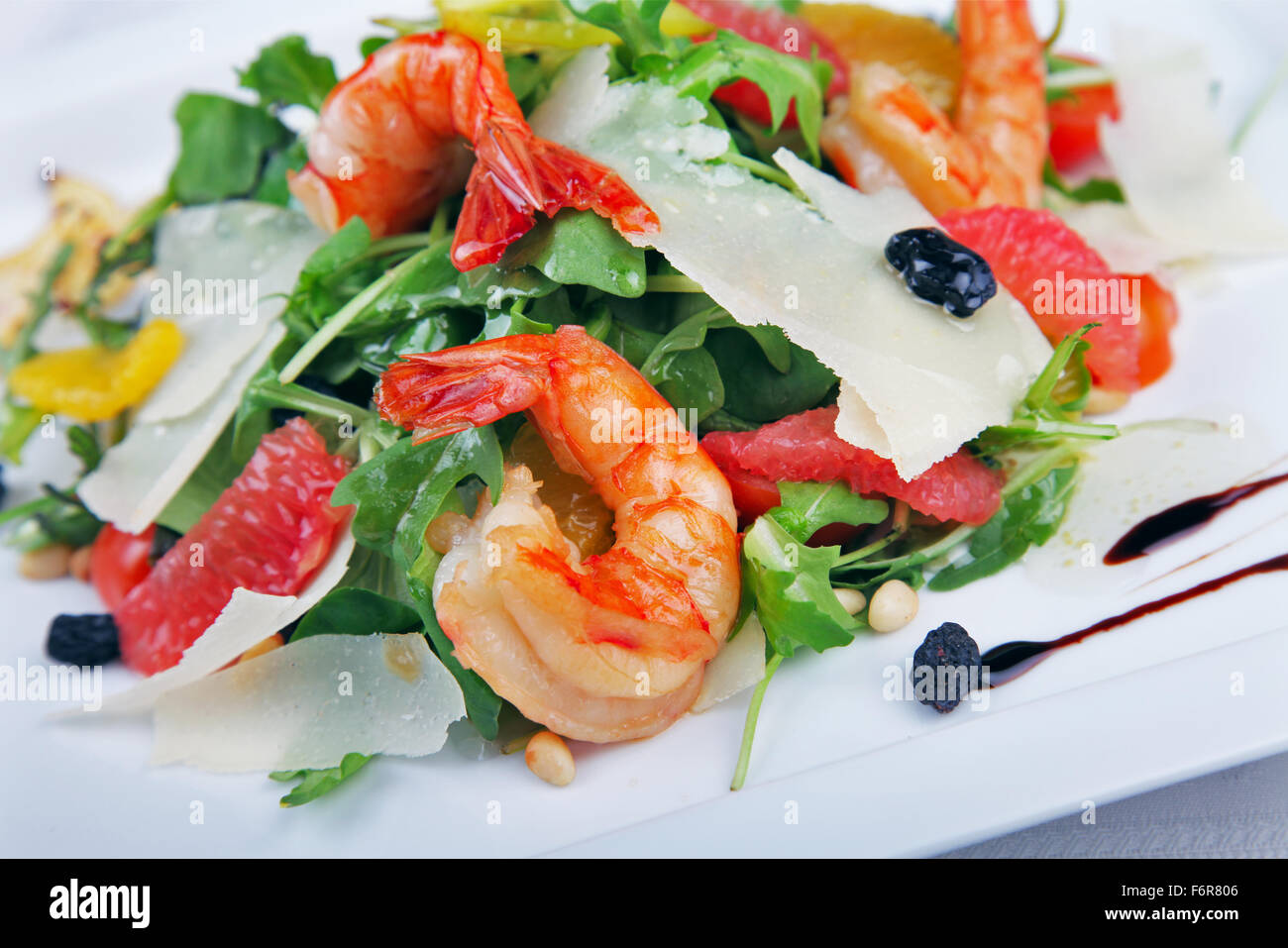 Big shrimp and green salad with cheese on plate Stock Photo
