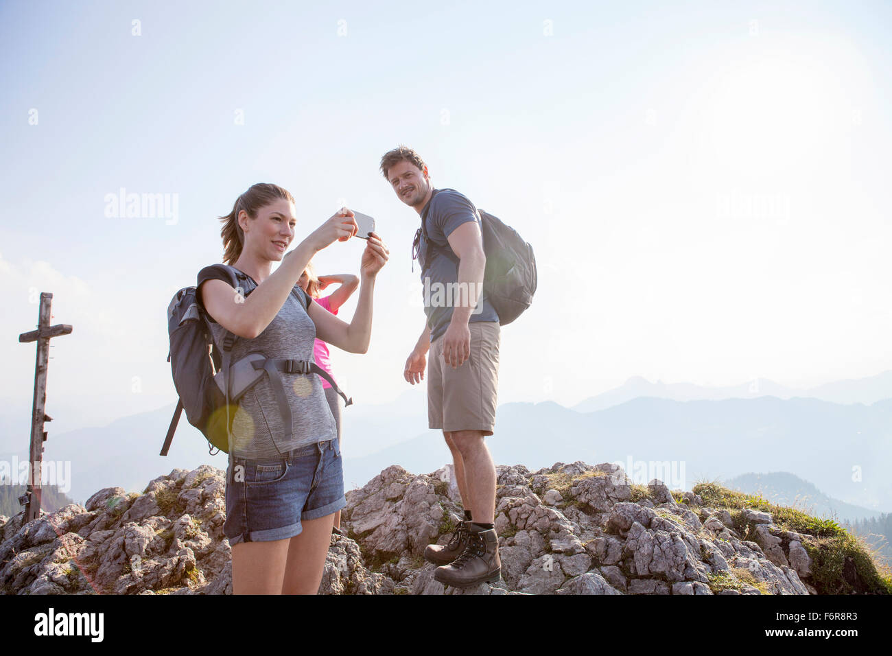 Group of friends taking pictures in mountain landscape Stock Photo