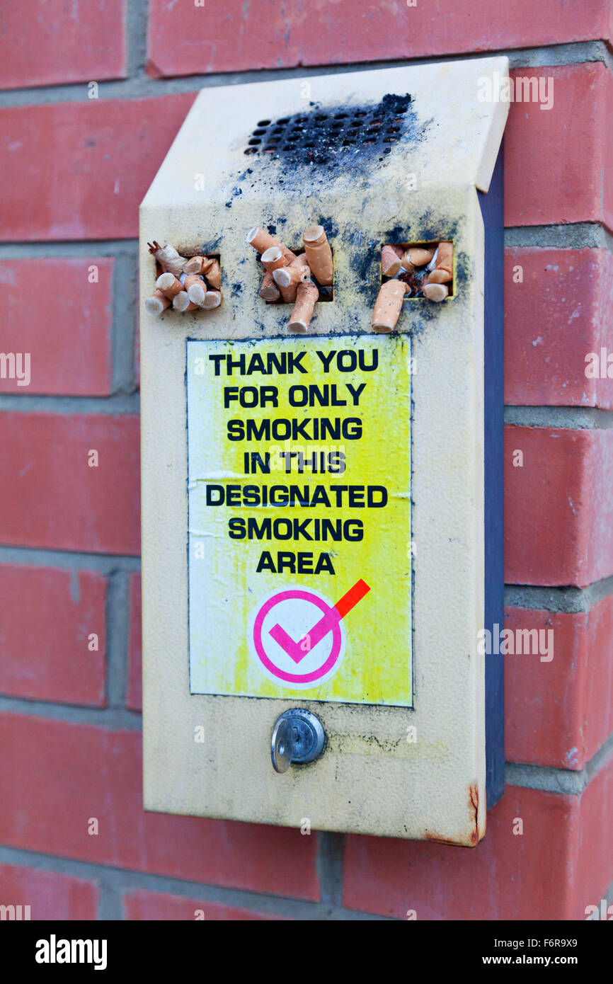 Cigarette bin with sign: Thank you for only smoking in this designated  smoking area Stock Photo - Alamy