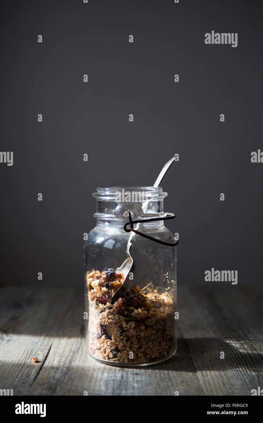 Jar of Homemade Granola with Nuts, Seeds Raisins & Cranberries with Spoon Stock Photo