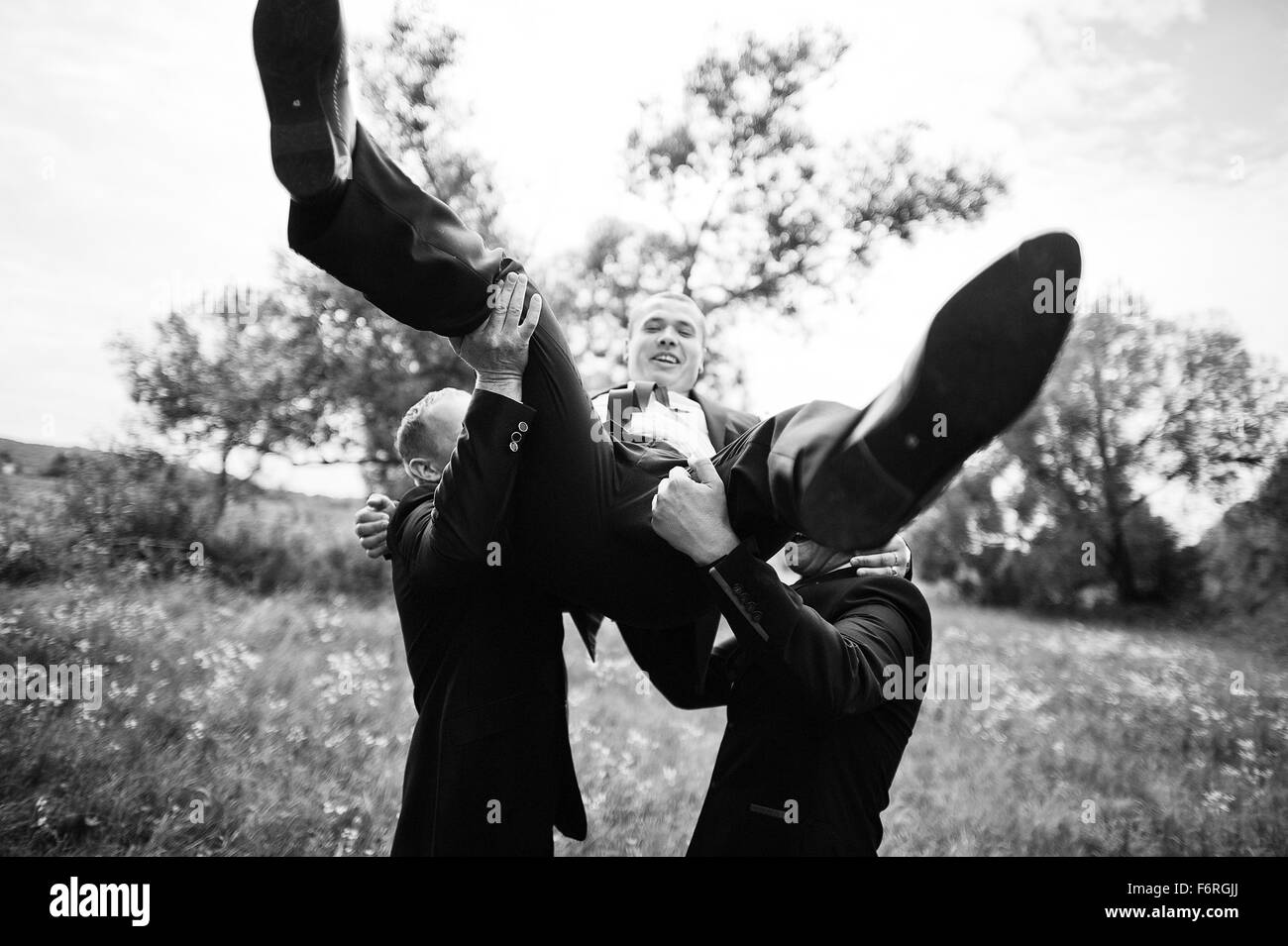 Groomsmen throw in hands groom Stock Photo Alamy