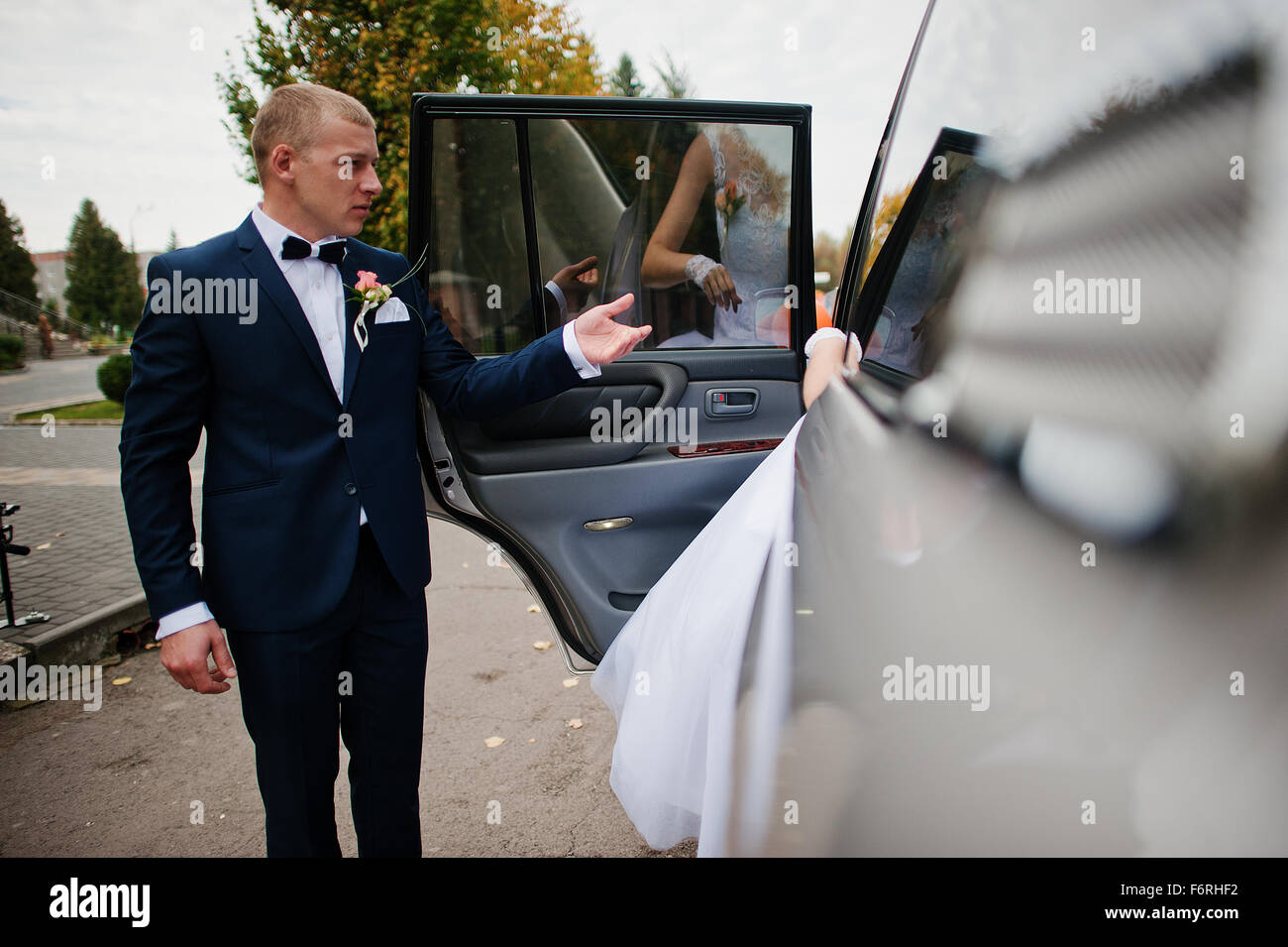 the groom takes the bride hand in the car Stock Photo - Alamy