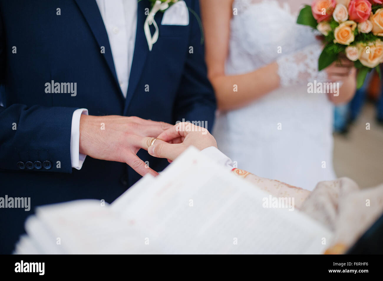 priest wear ring on finger of groom Stock Photo Alamy