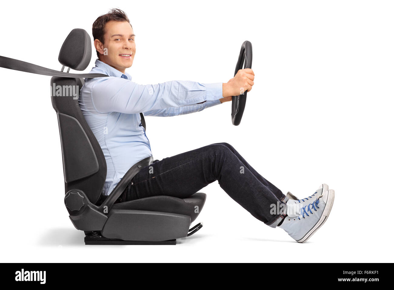 Profile shot of a young man driving seated on car seat and looking at