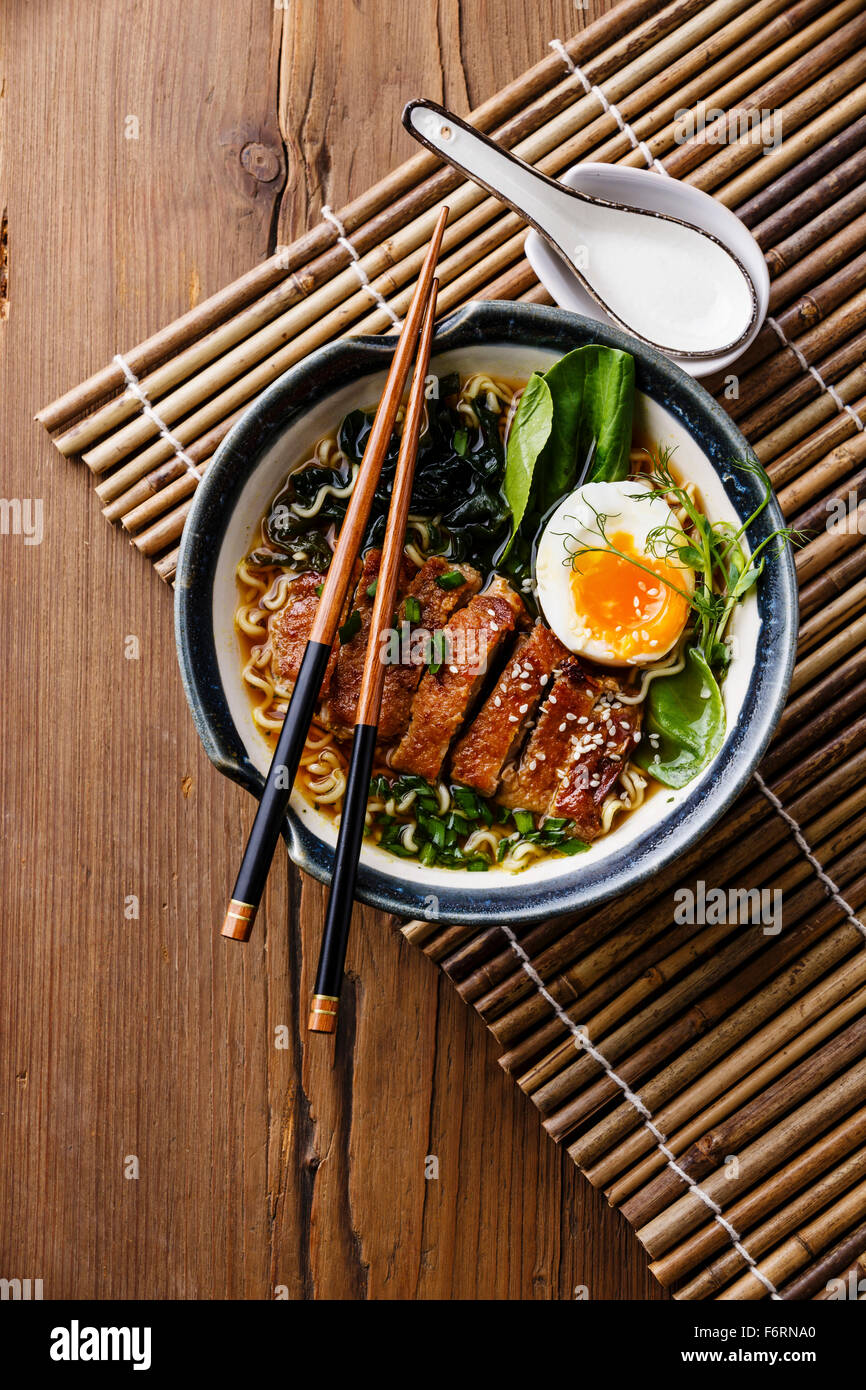 Duck noodles with egg and pak choi cabbage in bowl on wooden background Stock Photo