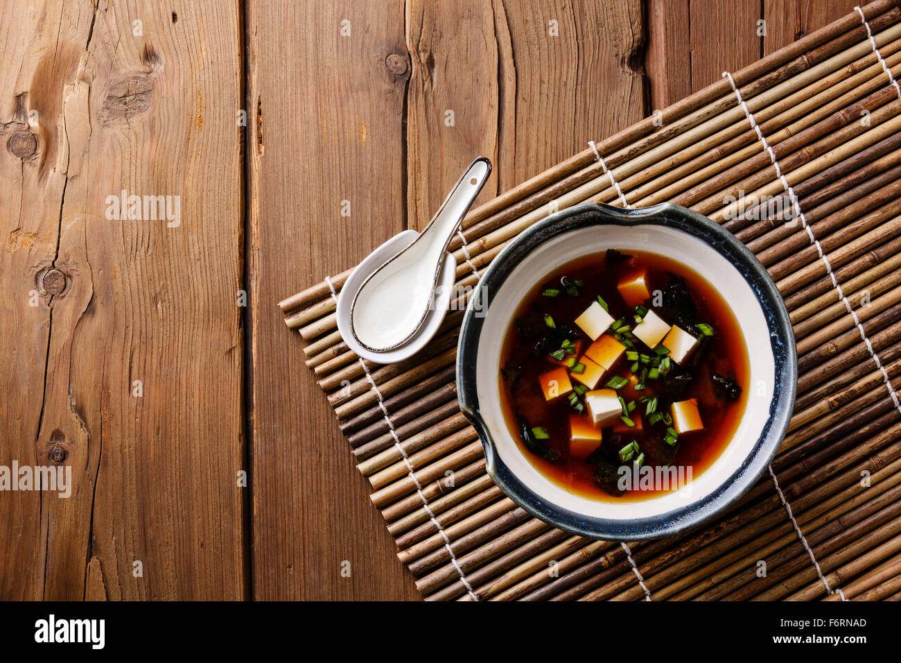 Miso Soup with tofu in bowl on bamboo background Stock Photo