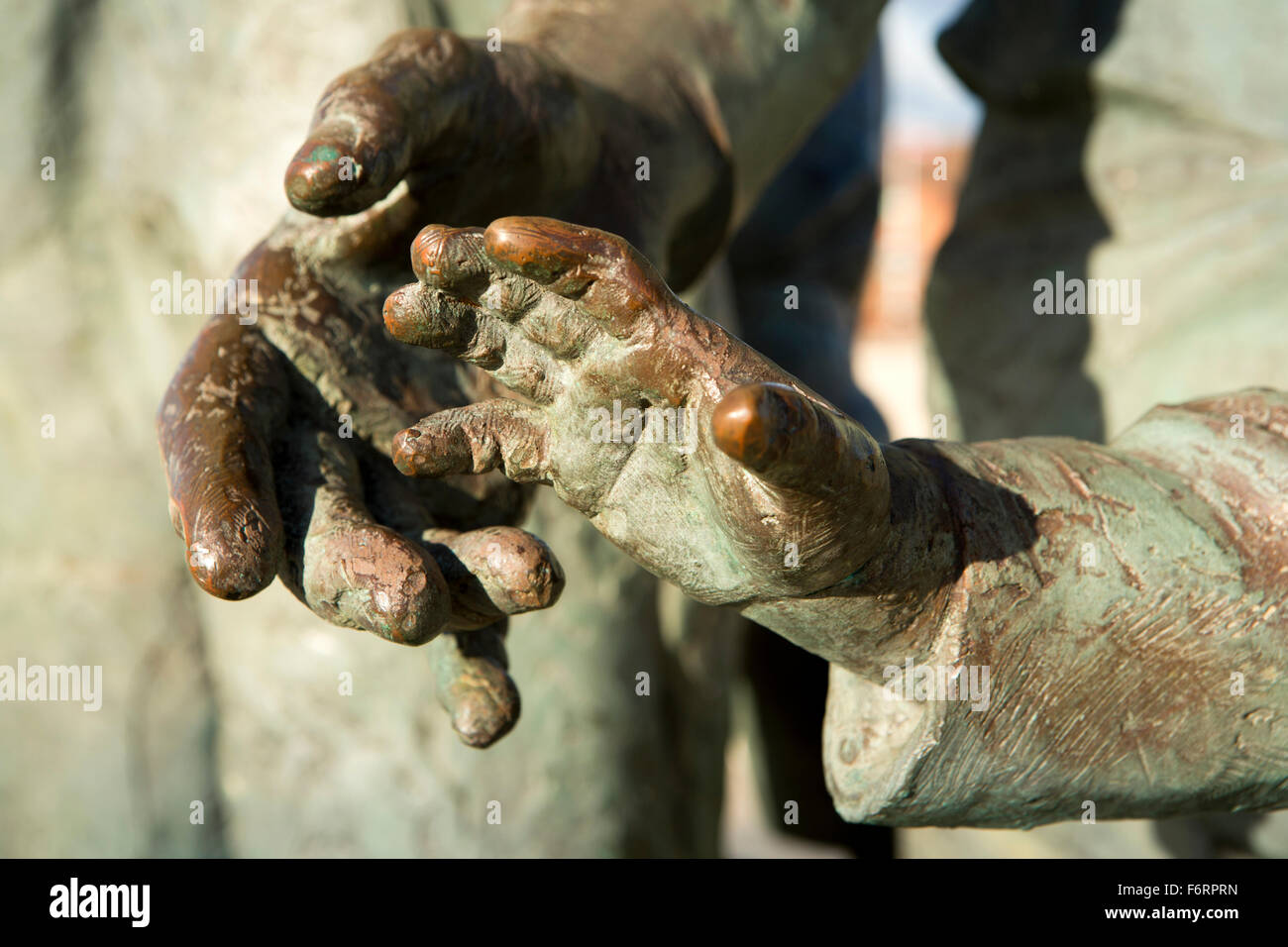 UK, England, Yorkshire, Hull, Humber Quays, bronze adult and child’s hands of Neil Hadlock’s emigrants sculpture Stock Photo