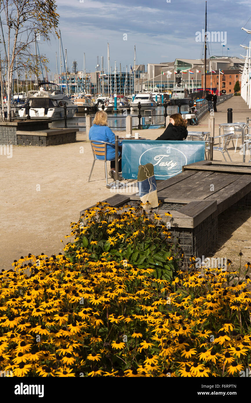 UK, England, Yorkshire, Hull, Princes Dock Road, women sat at Tasty Café’s quayside tables Stock Photo
