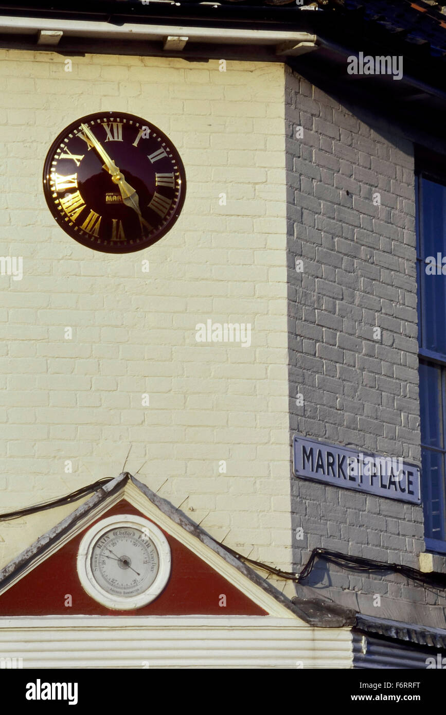A modern clock above an aneroid barometer at market place. Holt