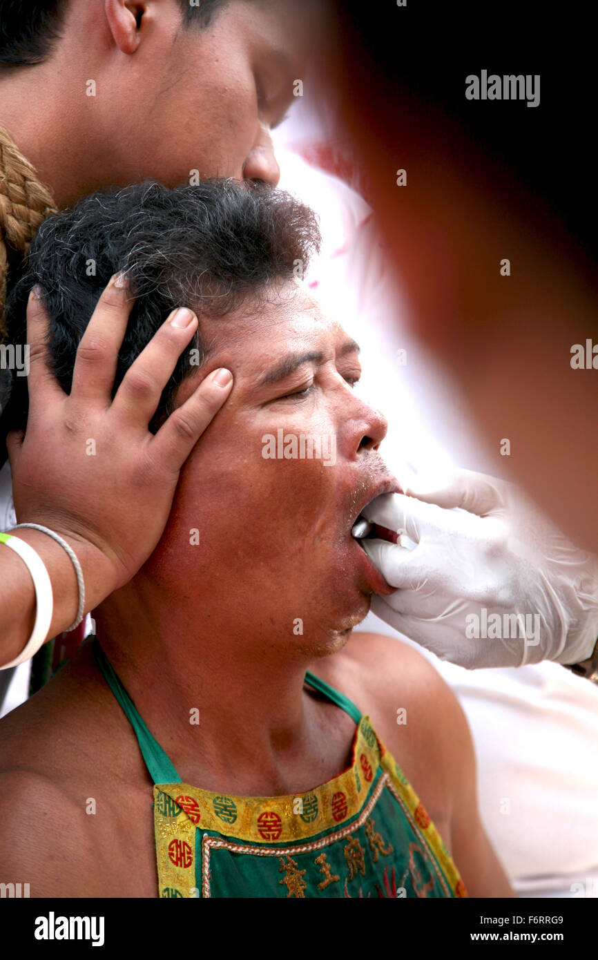 Thailand Phuket Festivals A Mah Jong going through the ritual of face piercing  Adrian Baker Stock Photo