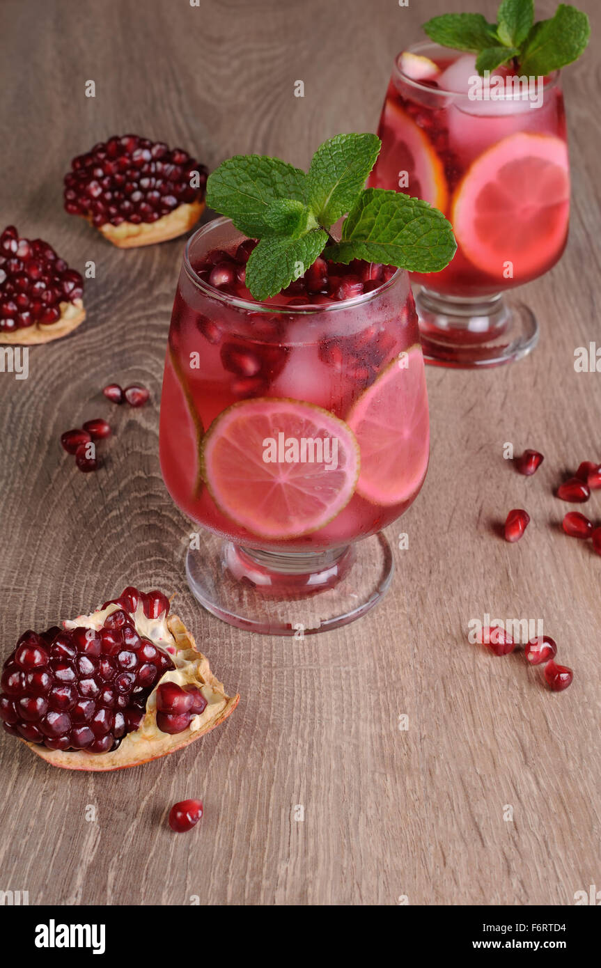 Pomegranate cocktail with slices of lime, mint and ice Stock Photo