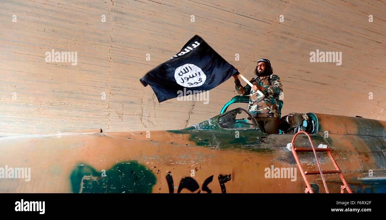 Islamic State of Iraq and the Levant propaganda photo showing militants waving the ISIS black banner of Muhammad inside a captured government fighter jet following the battle for the Tabqa air base August 2014 in Raqqa, Syria. Stock Photo