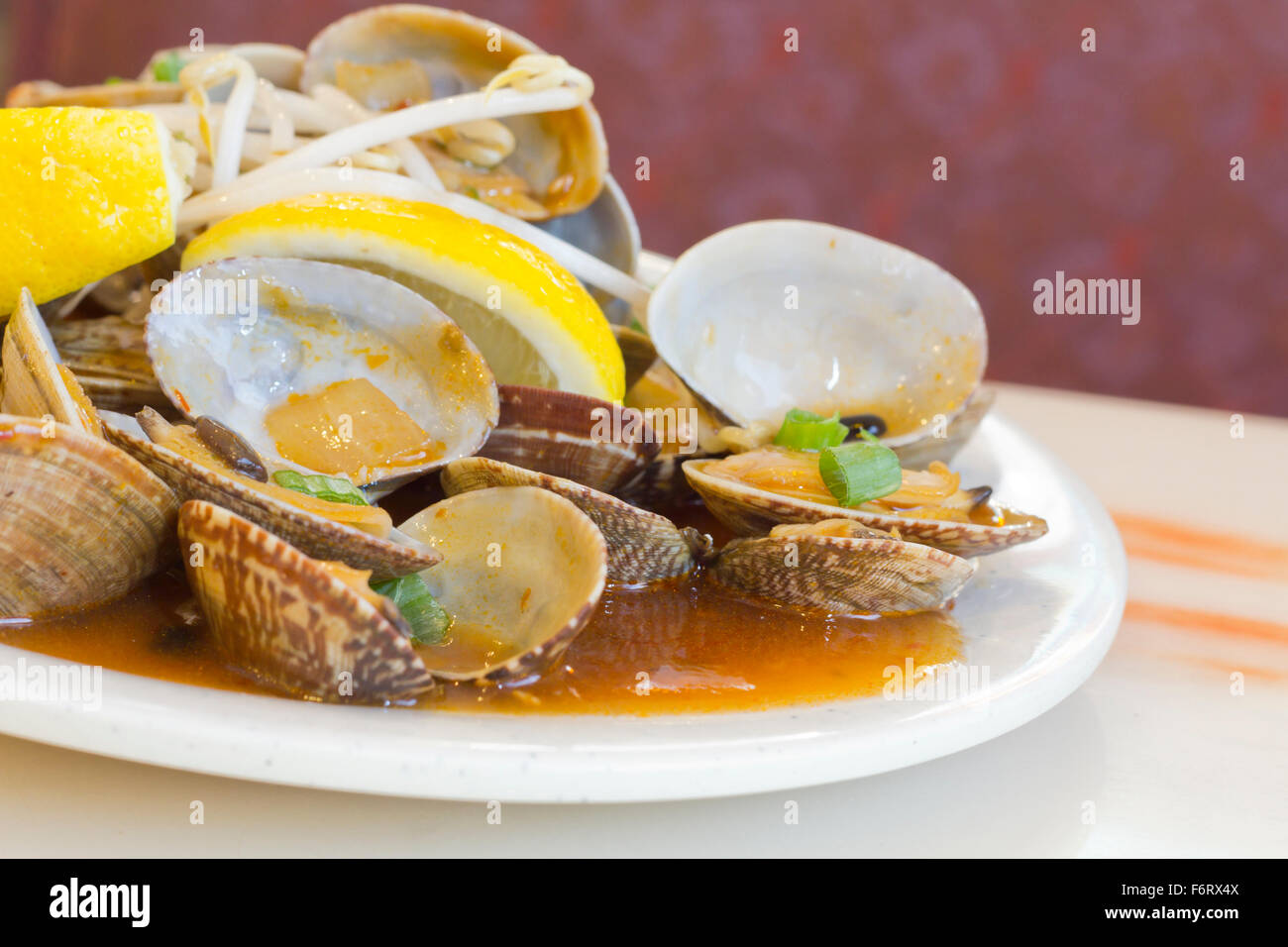 Chinese baby clams sauteed in sweet and spicy black bean sauce with lemon wedge Stock Photo Alamy