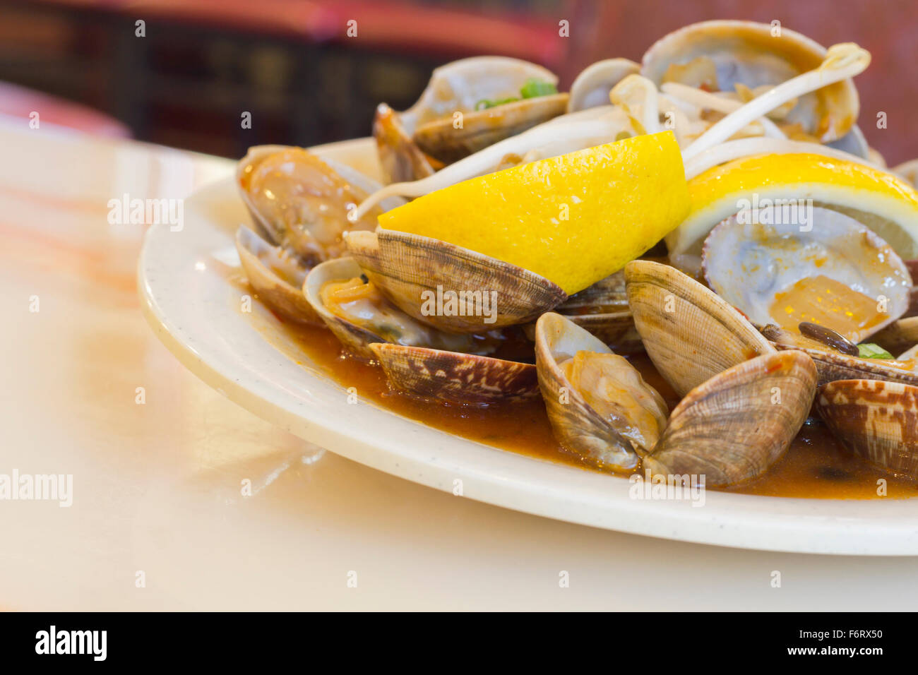 Chinese baby clams sauteed in sweet and spicy black bean sauce with lemon wedge Stock Photo Alamy