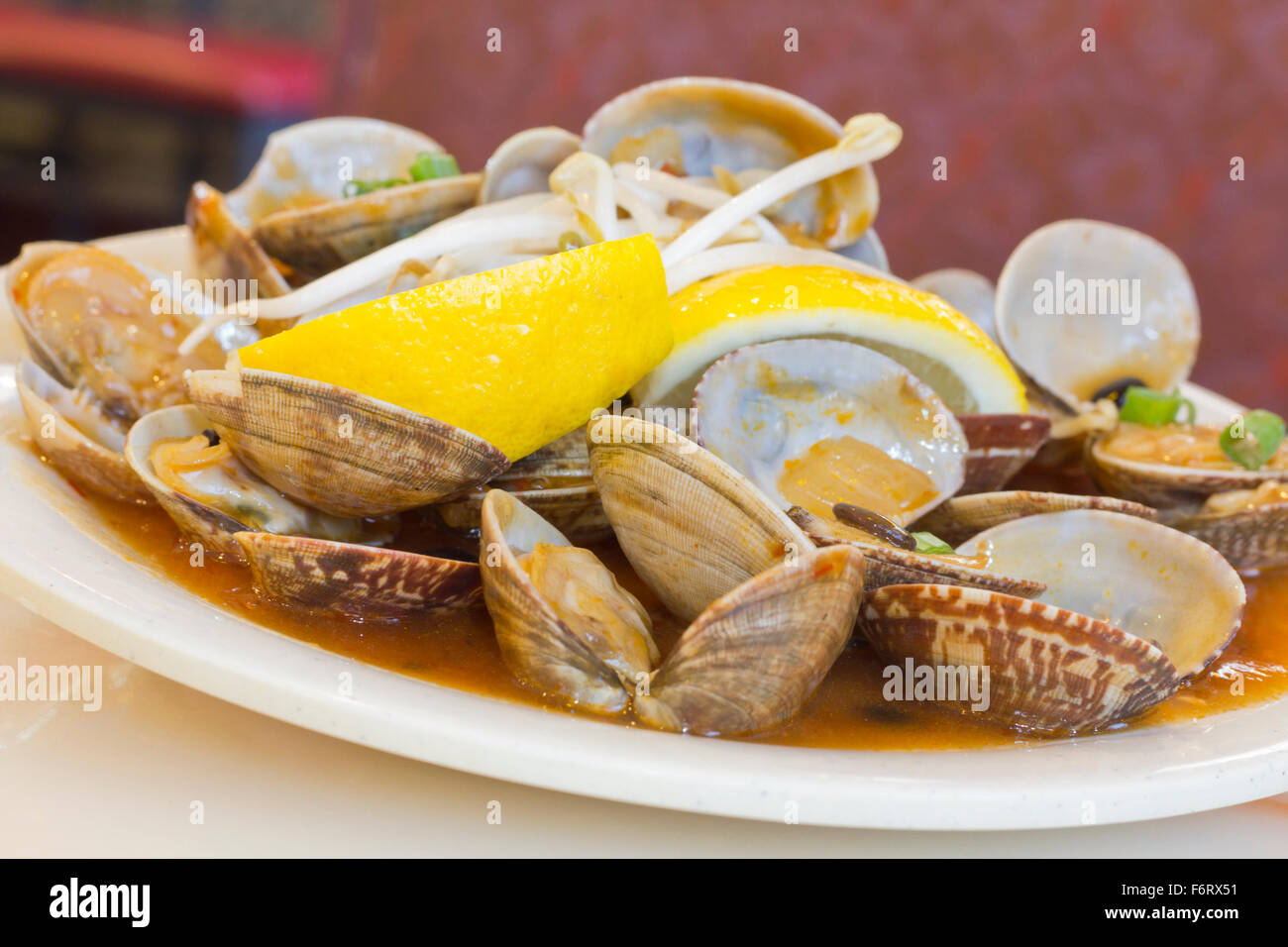 Chinese baby clams sauteed in sweet and spicy black bean sauce with lemon wedge Stock Photo Alamy