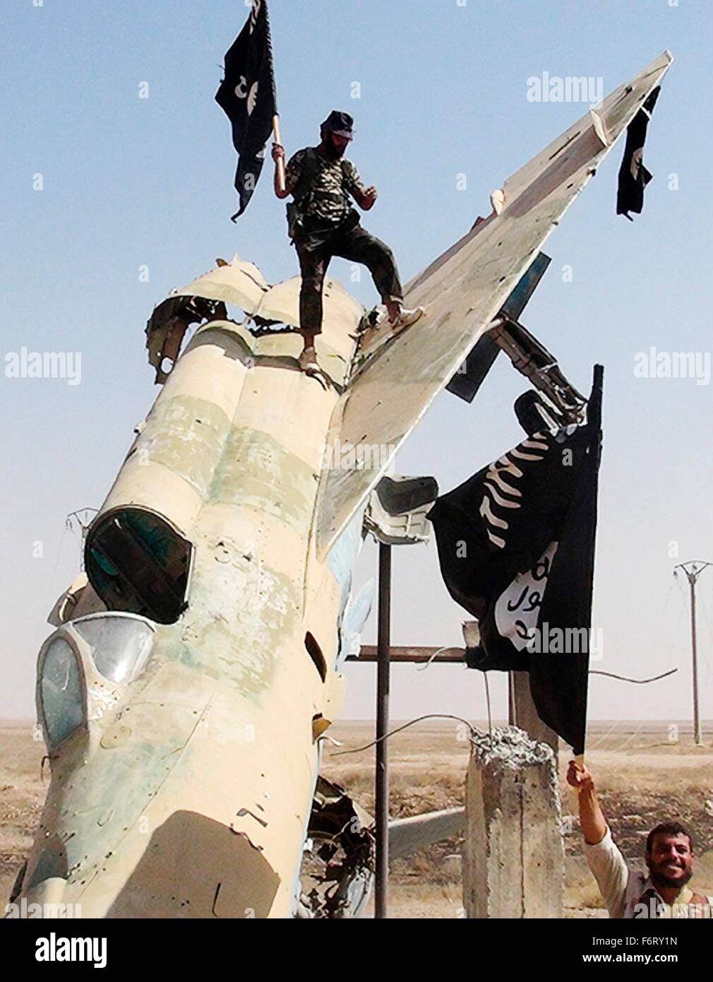 Islamic State of Iraq and the Levant propaganda photo showing militants waving the ISIS black banner of Muhammad on a fighter jet following the battle for the Tabqa air base August 2014 in Raqqa, Syria. Stock Photo