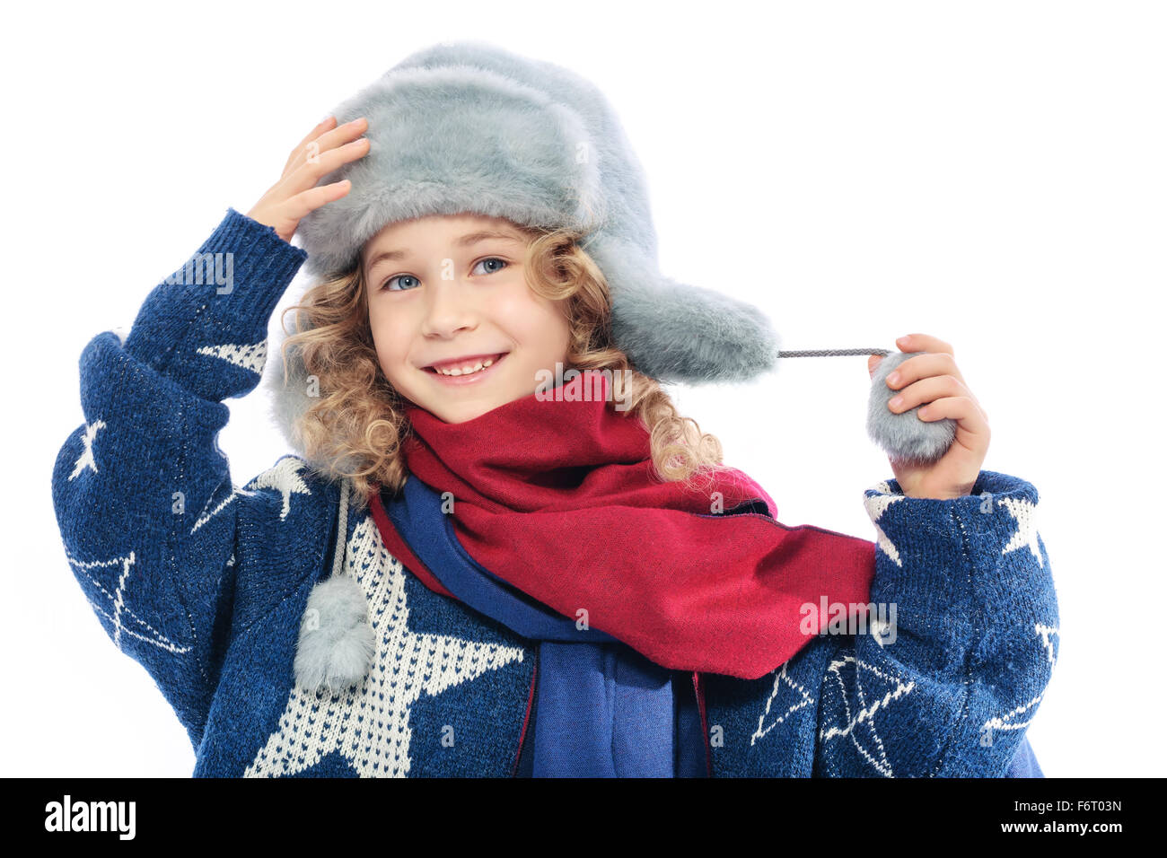 Girl wearing winter fur hat.Portrait of a child dressed in winter hat and mom's knitted warm sweater.On her neck she is wearing Stock Photo