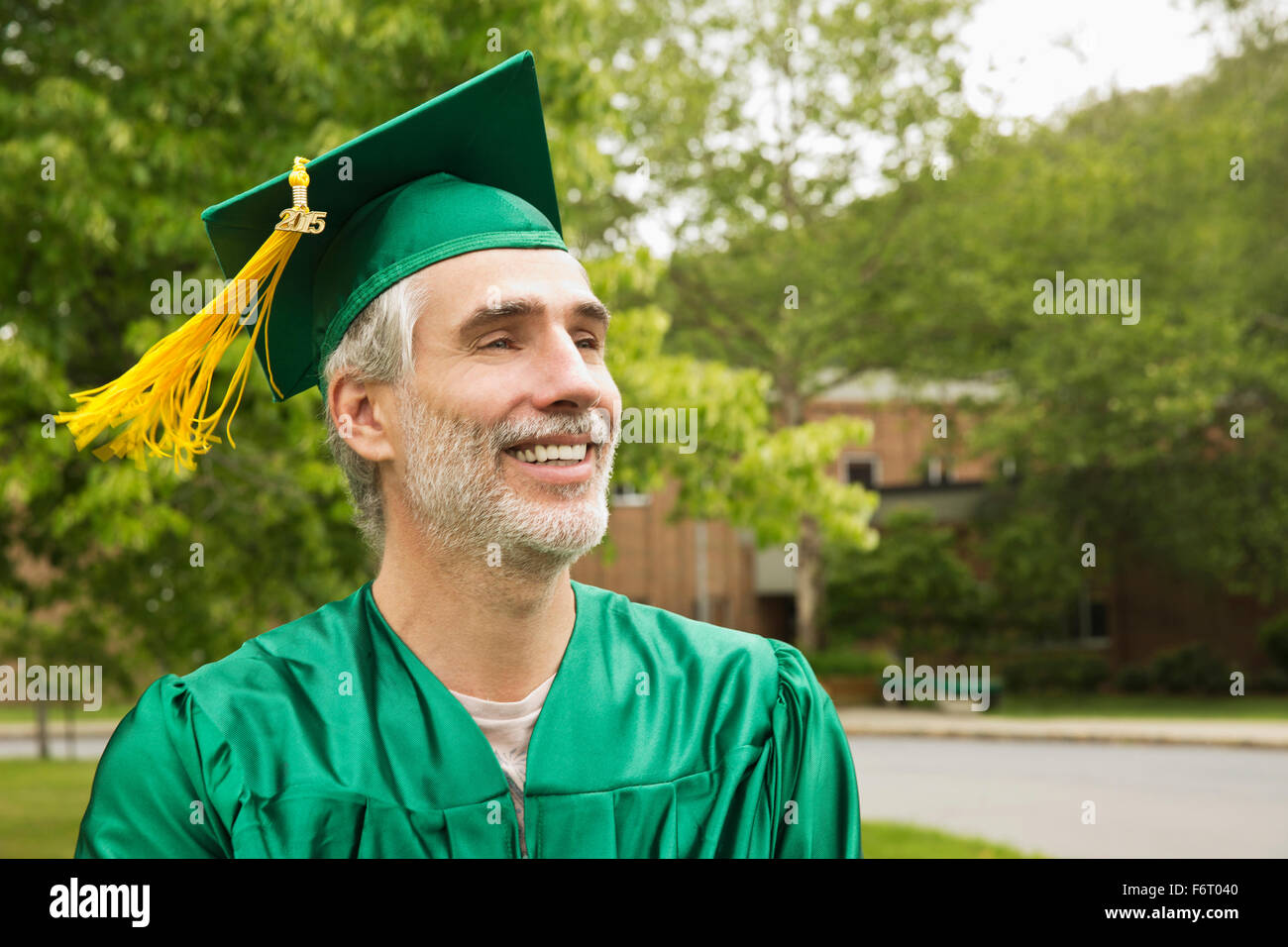 Caucasian college graduate wearing cap and gown Stock Photo