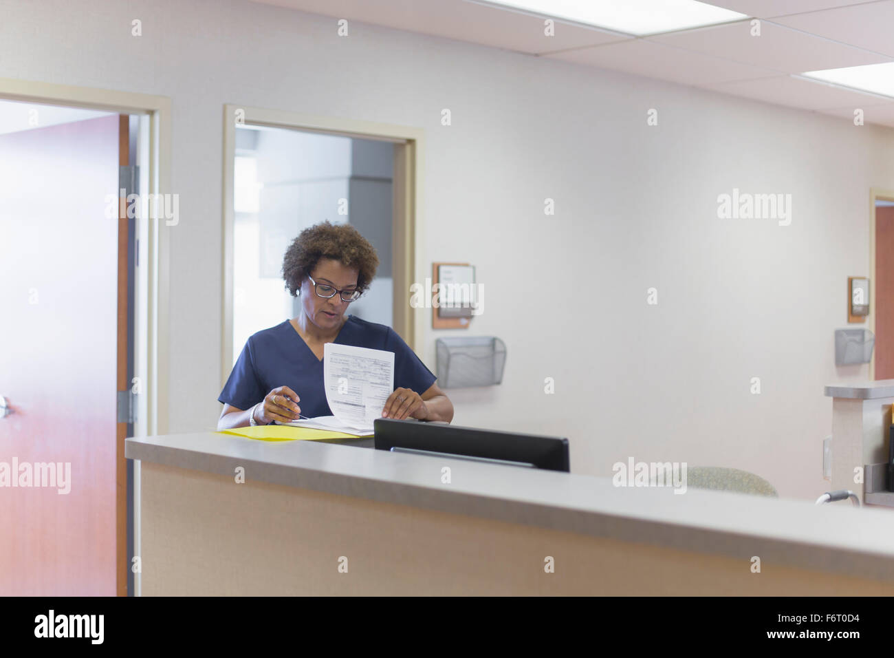 African American nurse writing in hospital Stock Photo
