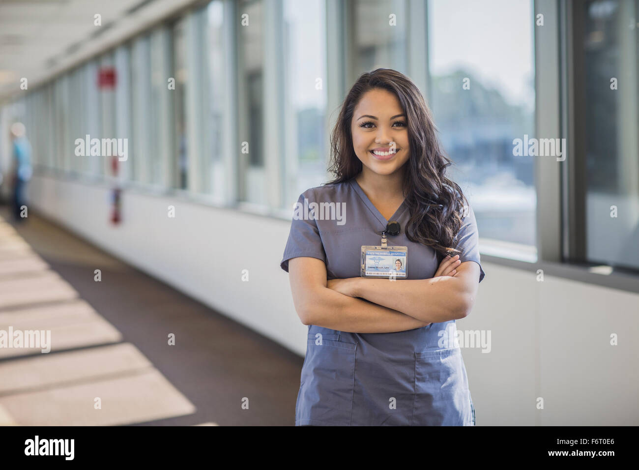 Mixed race nurse smiling in hospital hallway Stock Photo
