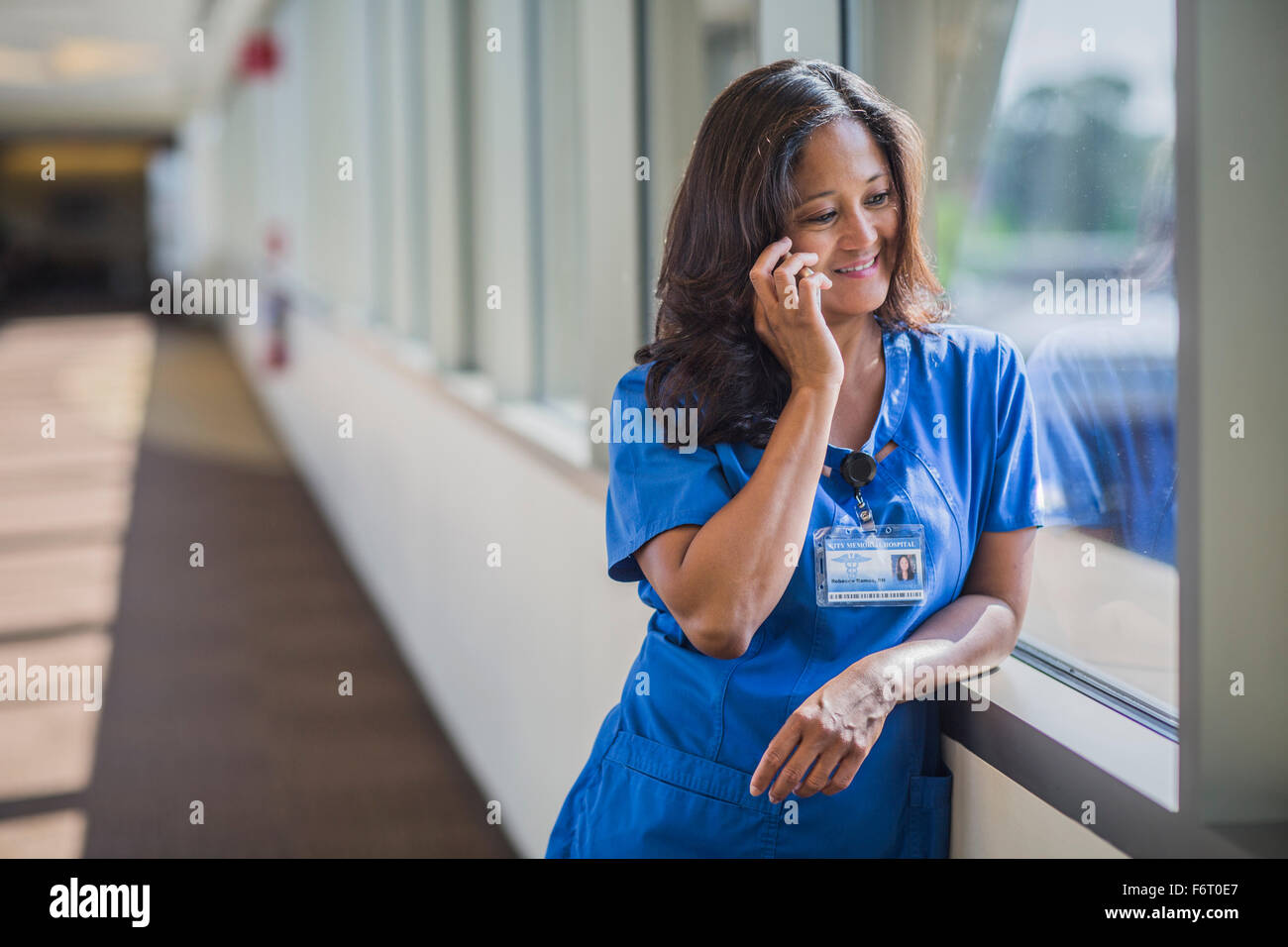 Filipino nurse talking on cell phone Stock Photo