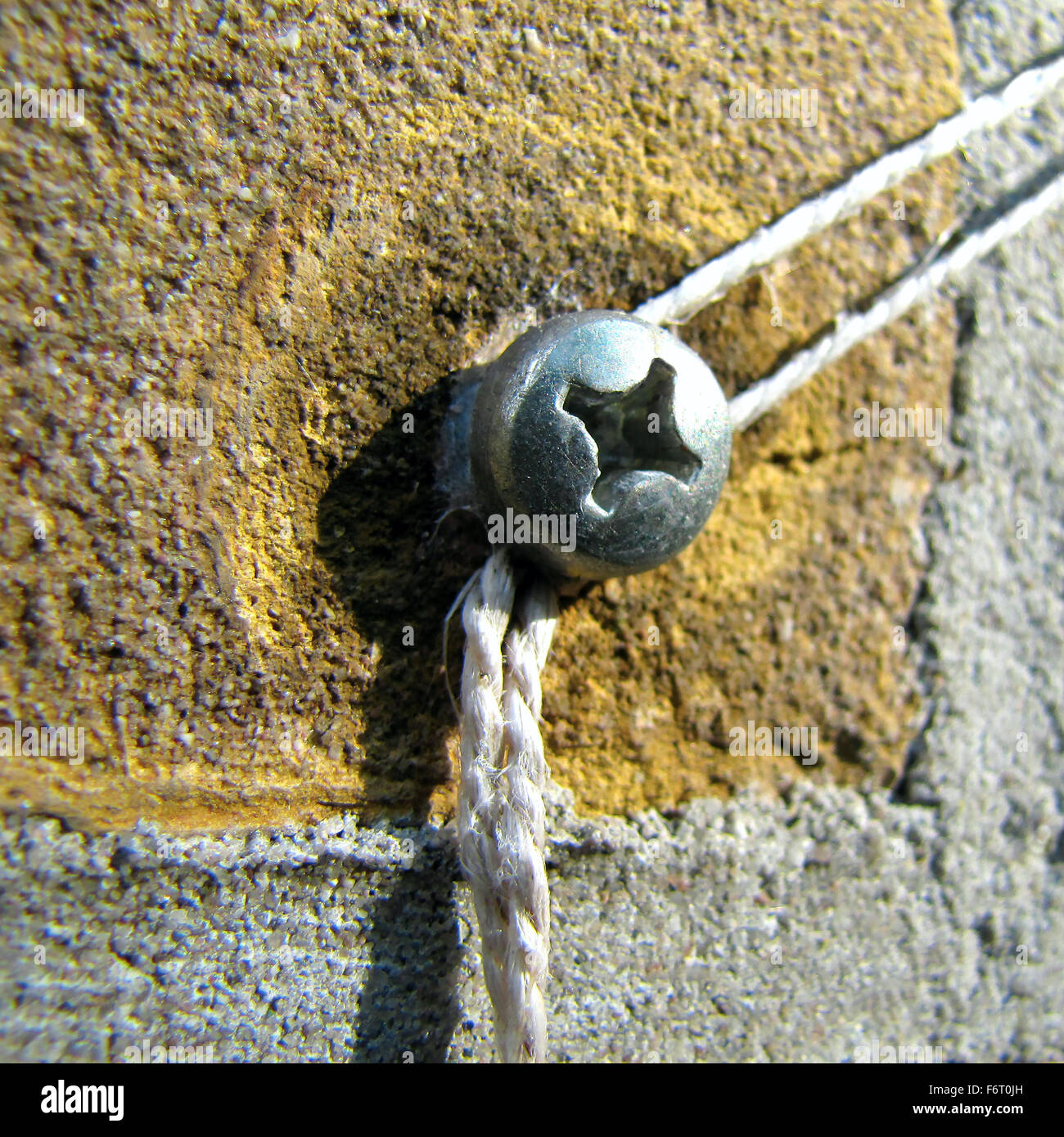 Screw in brick wall with string attached Stock Photo Alamy