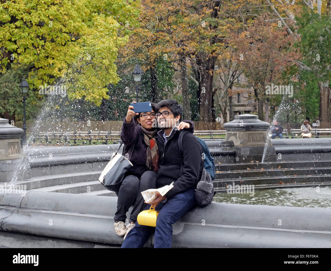 A attractive couple taking a selfie near the fountain in Washington Square Park in Greenwich Village, New York City Stock Photo