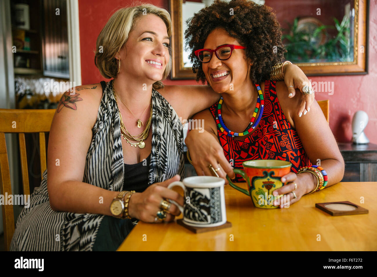 Hugging women drinking coffee Stock Photo