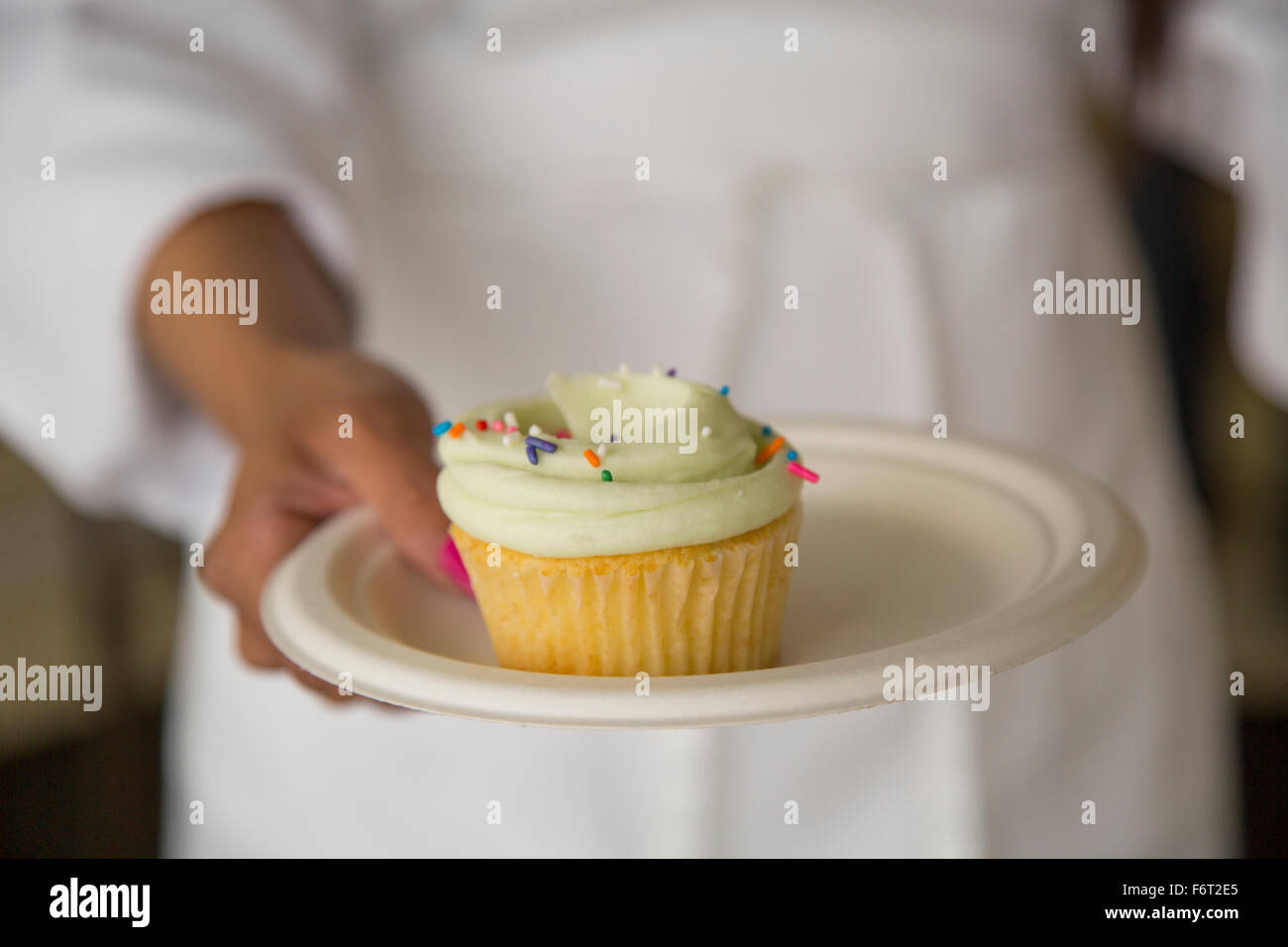Chef carrying plate of cupcake Stock Photo