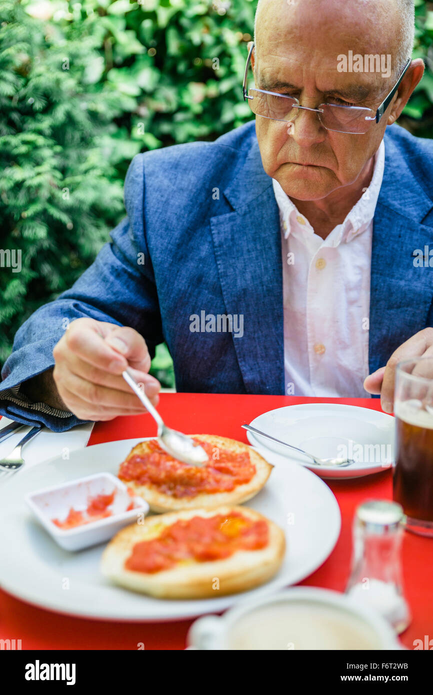Hispanic businessman eating breakfast outdoors Stock Photo